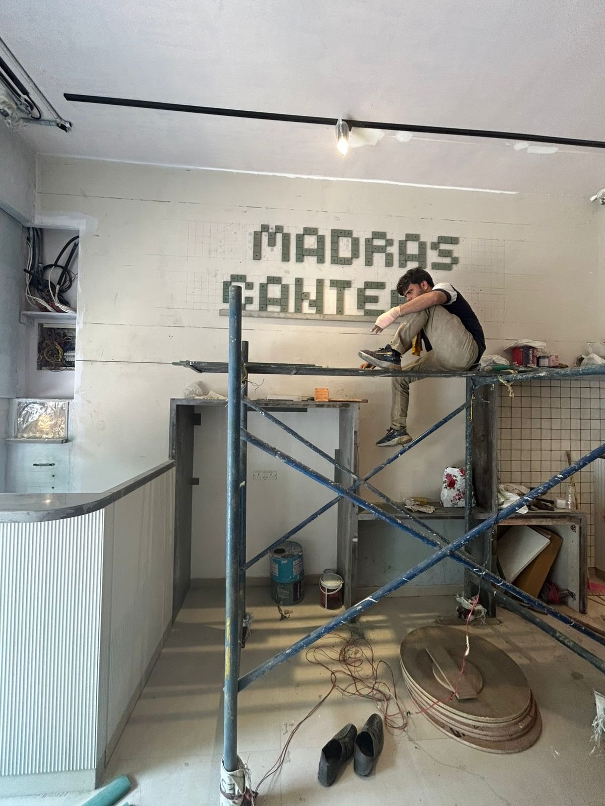 Madras Canteens interior during fit-out with scaffolding and wall lettering being installed