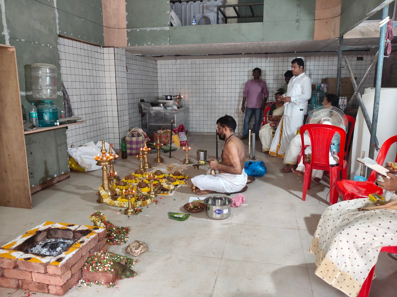 Pooja ceremony with brass lamps and offerings held in the restaurant space